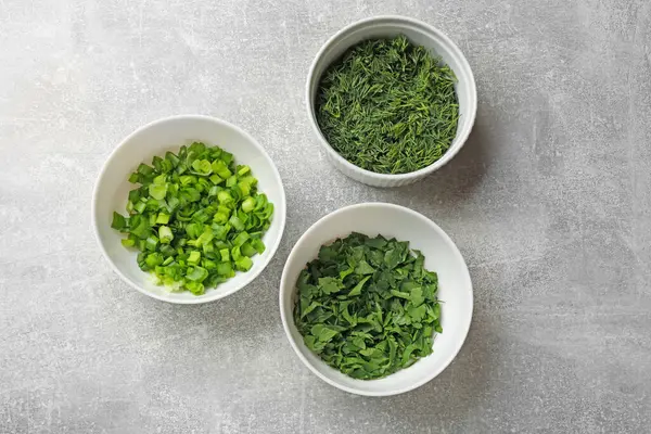 Gri masadaki kaselerde farklı taze otlar, düz yatıyordu.