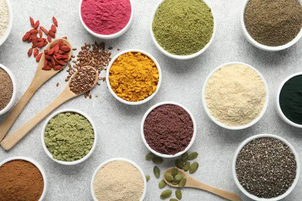 Açık gri masada farklı süper yiyecek tozları, düz yatıyordu.