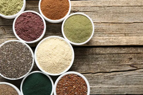 Tahta masadaki kaselerdeki farklı süper yiyecekler, düz yatış. Metin için boşluk