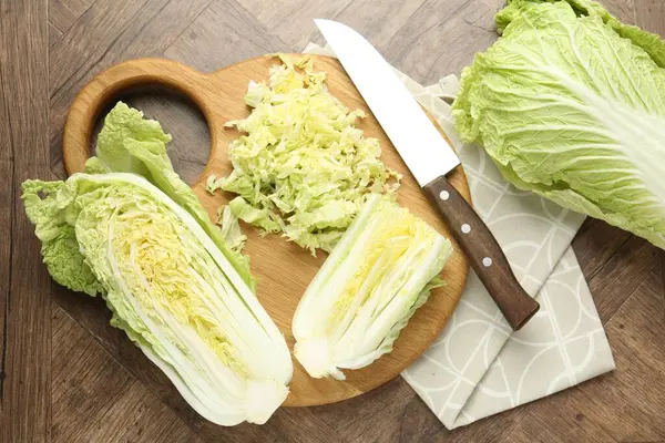 Taze Çin lahanaları ve bıçak ahşap masada, düz yatıyordu.