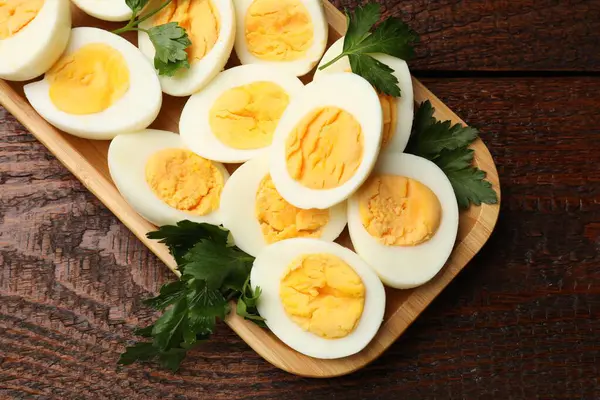 Haşlanmış yumurta ve maydanoz ahşap masada, üst manzara.