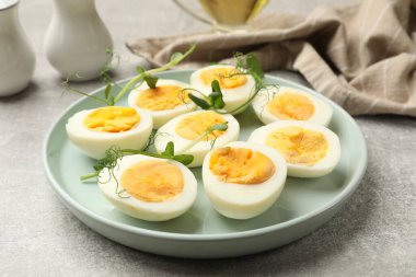 Gri masadaki mikro yeşilli haşlanmış yumurtalar, yakın plan.