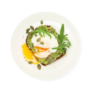 Avokadolu lezzetli sandviç, haşlanmış yumurta, roka ve balkabağı çekirdekleri beyaza izole edilmiş.