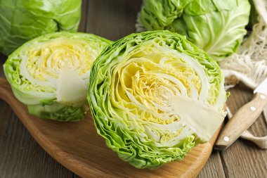 Taze lahanalar, ağ torbası ve bıçak ahşap masada, yakın plan.