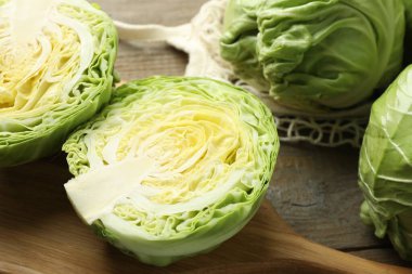 Taze lahanalar ve ahşap masada ağ torba, yakın plan.