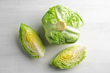 Taze taze lahana ve açık ahşap masa üzerinde kesilmiş lahanalar.