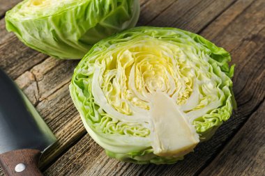 Tahta masada taze lahana ve bıçak yarıları, yakın plan.