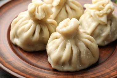 Lezzetli pişmiş khinkali masada servis ediliyor, yakın plan.