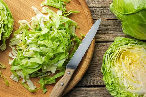 Tahta masada taze lahana ve bıçak kes, düz uzan.