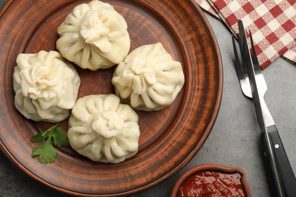 Gri masadaki sosla servis edilen lezzetli khinkali.