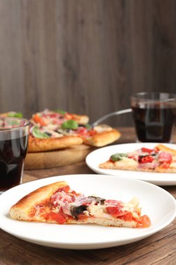 Ahşap masada servis edilen ince füme sosisli, lezzetli pizza dilimleri.