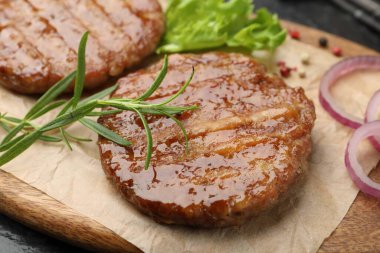 Lezzetli hamburger köfteleri ve baharatlar masada, yakın plan.