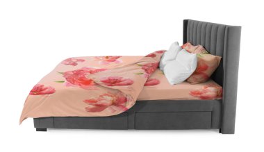 Beyaz arka planda güzel çarşaflarla yapılmış bir yatak. Çiçek desenli kumaş