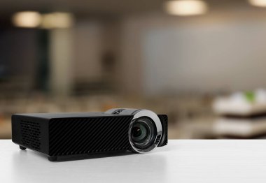 Konferans odasındaki beyaz masada modern video projektörü