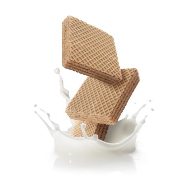 Lezzetli gevrek gofretler beyaz arka plana süt sıçratıyor.