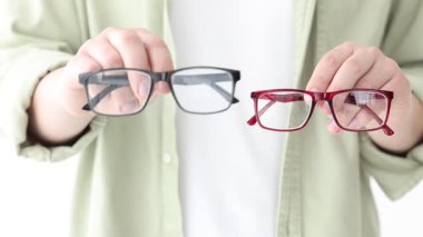 Beyaz arkaplanda çift gözlük gösteren kadın, yakın plan