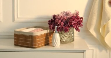 Banyoda ellerini temiz waffle havlusuyla silen bir kadın, yakın plan. Kamera sağa hareket ediyor