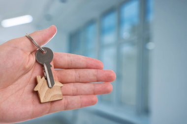 Emlakçı evin anahtarını tutuyor, yakın plan. Metin için boşluk