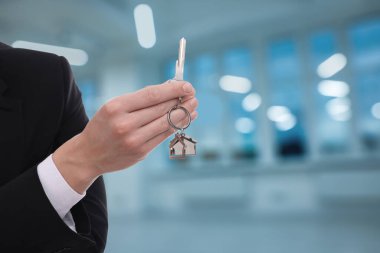 Emlakçı evin anahtarını tutuyor, yakın plan. Metin için boşluk