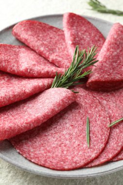 Beyaz desenli masada servis edilen biberiyeli leziz sosis dilimleri.