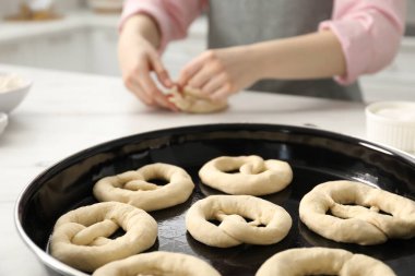 Mutfaktaki masada simit şekillendiren kadın, seçici odaklanma.