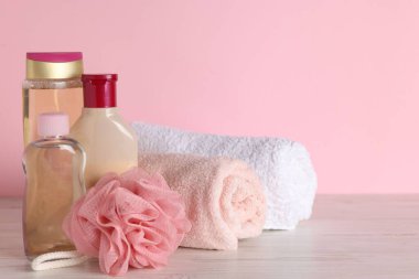Farklı banyo aksesuarları açık ahşap masada pembe arka planda, yakın planda. Metin için boşluk