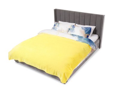 Beyaz arka planda güzel çarşaflarla yapılmış bir yatak.