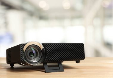 Ofisteki ahşap masada modern video projektörü