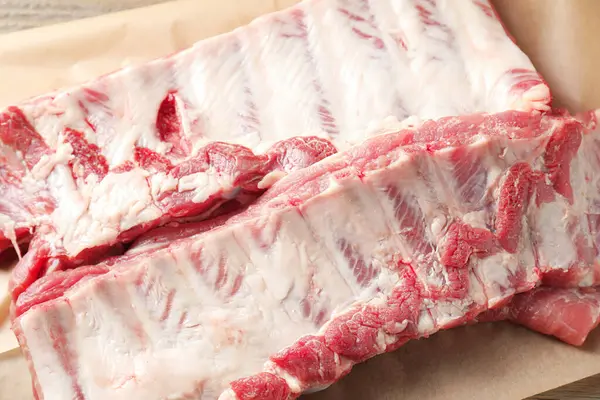 Ahşap masada çiğ domuz pirzolası, yakın plan.