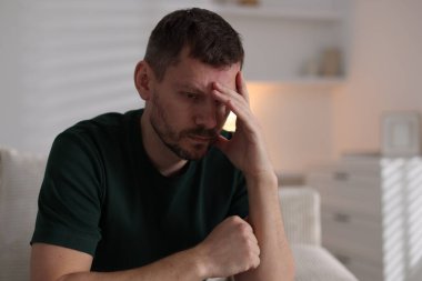 Evdeki kanepede depresif bir adam. Zihinsel sağlık sorunu