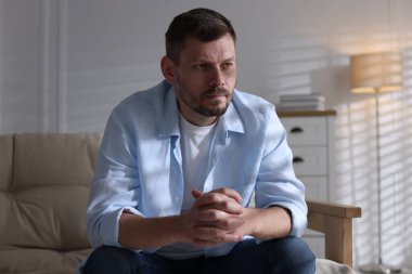 Evdeki kanepede depresif bir adam. Zihinsel sağlık sorunu