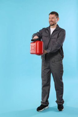 Açık mavi arkaplanda plastik kutu tutan adam, metin için boşluk