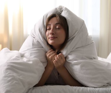 Evdeki battaniyeye sarılı güzel bir kadın.