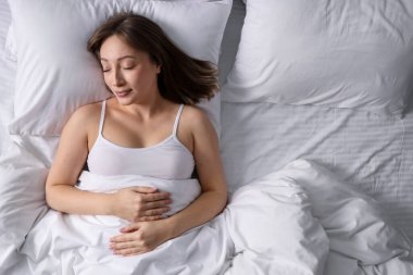 Evdeki yatakta uyuyan güzel bir kadın.