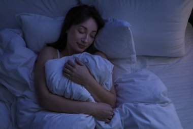 Evdeki yatakta uyuyan güzel bir kadın.