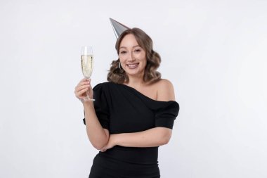 Doğum günü kutlaması. Beyaz arka planda bir kadeh köpüklü şarap içen kadın.