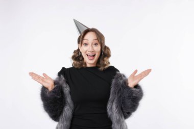 Doğum günü kutlaması. Beyaz arka planda parti konisi olan heyecanlı bir kadın.