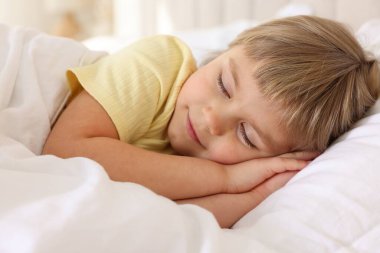 Yatma vakti. Yatakta uyuyan tatlı küçük kız.