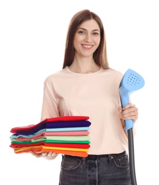 Buharlı gülen kadın ve beyaz arka planda bir yığın kıyafet.