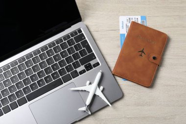 Pasaport, uçuş bileti, uçak modeli ve dizüstü bilgisayar ahşap masada, düz konum