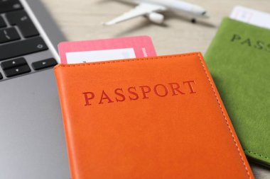 Pasaportlar, uçuş biletleri, uçak modeli ve dizüstü bilgisayar masada, yakın plan.