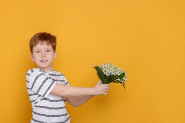 Sarı arka planda vadideki güzel çiçekleri olan çocuk. Metin için boşluk