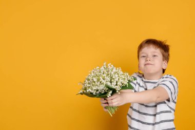 Sarı arka planda vadideki güzel çiçekleri olan çocuk. Metin için boşluk