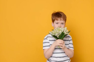 Sarı arka planda vadideki güzel çiçekleri olan çocuk. Metin için boşluk