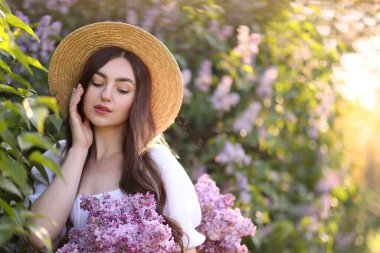 Leylak çiçeklerinin arasında güzel bir kadın ve sabah dışarı çıkıyor. Metin için boşluk