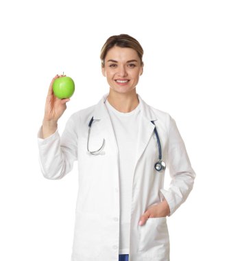 Beyaz arka planda yeşil elmalı ve steteskoplu beslenme uzmanı.