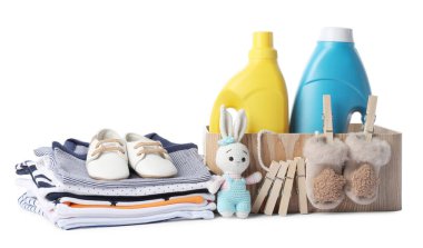 Kumaş yumuşatıcı, ayakkabı, bebek kıyafetleri, mandallar ve beyaz üzerine izole edilmiş oyuncaklar.