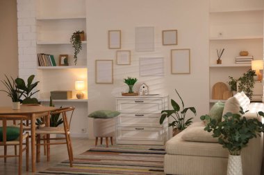 Odada rahat bir kanepe ve sandalyeli şık bir yemek masası. İç tasarım