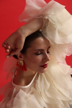 Kırmızı arka planda şık giyinmiş genç bir kadın.