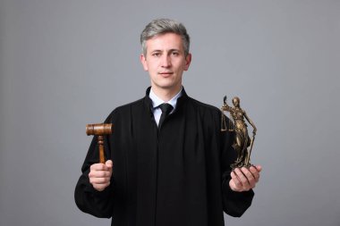 Gri arka planda Adalet Anıtı heykeli ve tokmakla hakim